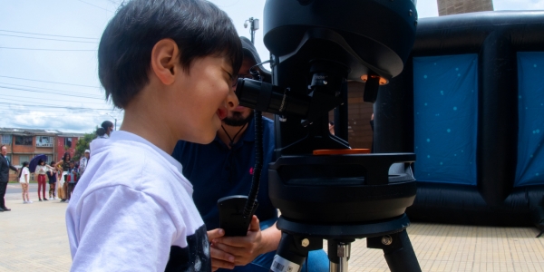 Niño mirando por telescopio