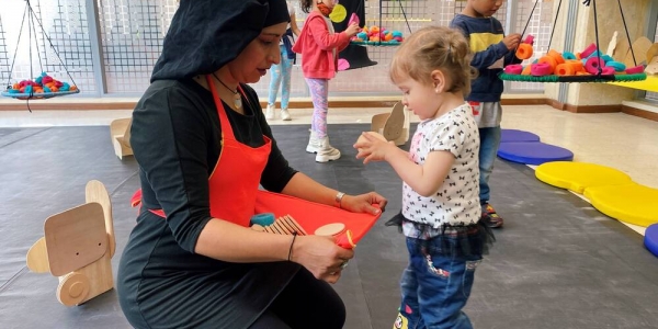 Niñas y niño con artista en laboratorio artístico