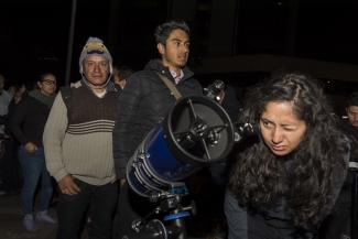 Mujer  viendo a través de un telescopio 