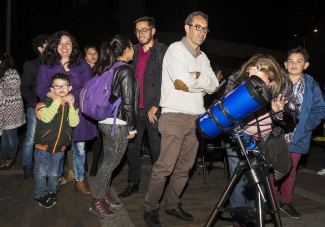 Mujer viendo a través de un telescopio 