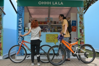 Jóvenes en bicicleta viendo  libros  