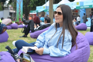 mujer disfrutando el sol sentada en el parque 