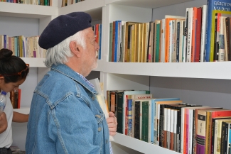 Adulto viendo libros en una estantería 