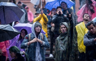 Público disfrutando del espectáculo bajo la lluvia.