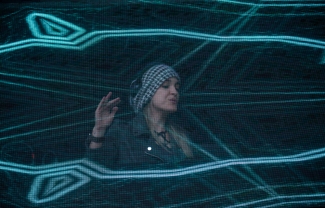 Mujer con proyecciones de luz sobre el escenario