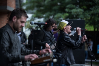 Hombre cantando y músicos en el escenario