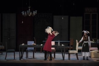 Mujeres en escena alrededor de una mesa 