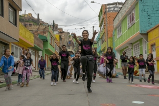 Grupo de bailarines recorriendo una calle