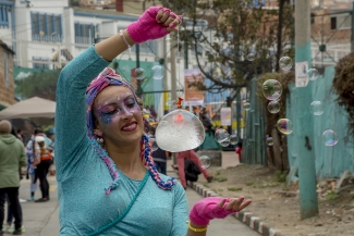 Mujer malabarista vestida de azul participando en una actividad artística