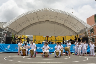 Grupo de  jóvenes y niños artistas con instrumentos en actividad al aire libre