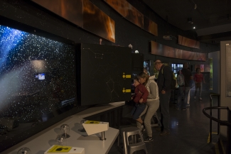 Grupo de personas observando una fotografía del espacio.