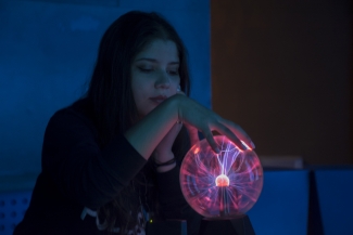 Mujer observando bola de color rosado y azul