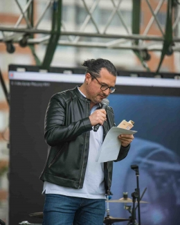 Artista en tarima realizando la lectura