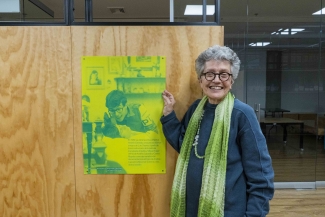 Rosario Caicedo junto a una foto de Andrés Caicedo en Andrés Caicedo: Morir y dejar obra.