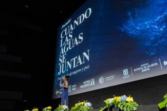 Cantante abriendo la proyección de Cuando las aguas se juntan